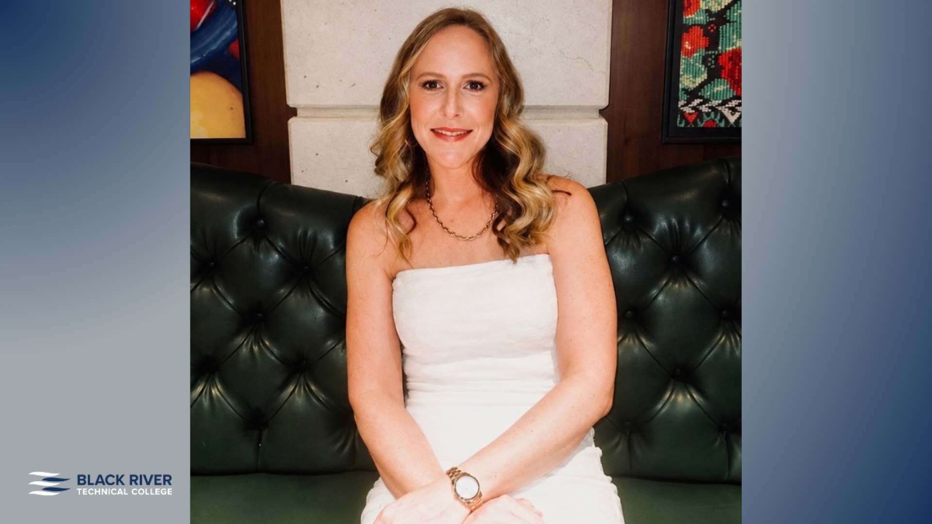 A woman with long wavy blonde hair, wearing a white strapless top, sits smiling on a dark green tufted leather couch, with Black River Technical College branding.